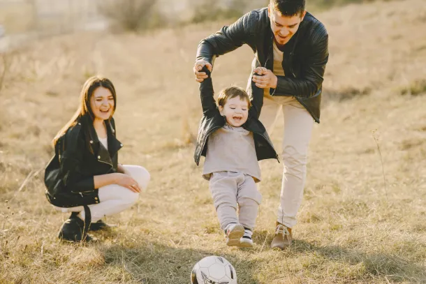 Familie beim Fußballspielen mit kleinem Kind